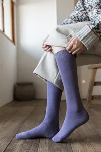 Detail shot of winter warm purple knee-high loop socks, vintage solid color long socks for women.