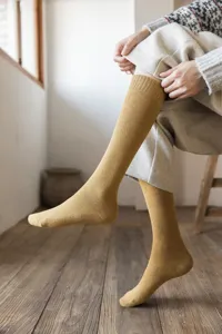 Detailed view of women's thick thermal knee high loop socks in solid mustard yellow color.