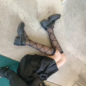 Trendy sheer black diamond pattern knee high socks paired with platform Mary Jane shoes.