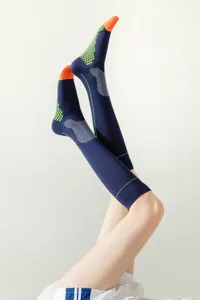 Detail view of athletic knee-high sports socks with grip dots, featuring blue and orange.