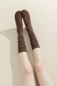 Close-up detail of brown knit slouch socks, showing soft thick texture and ribbed design.