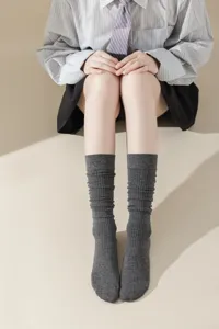 Détail de chaussettes slouch côtelées grises, texture tricot douce pour la mode féminine.