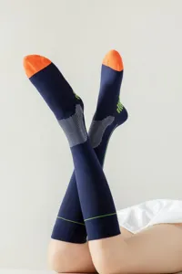Women's long athletic compression socks, dark blue with orange toes and breathable mesh.