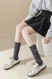 Chaussettes hautes côtelées grises avec broderie d'abeille délicate, tendance et confortable.
