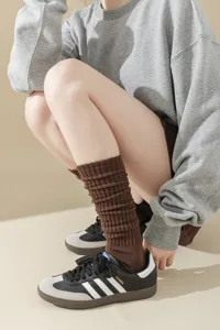Closeup detail of brown ribbed knit tube socks, stylish winter calf socks for women daily wear.