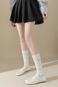 Chaussettes hautes blanches côtelées pour femmes avec une broderie d'abeille délicate.