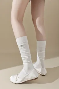 Chaussettes hautes côtelées blanches avec broderie abeille délicate et chaussures.