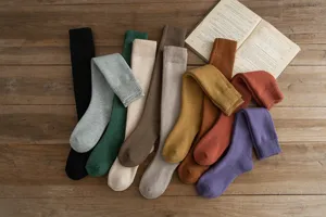 Detailed view of cozy winter thick thermal long socks in various solid colors on wooden background.