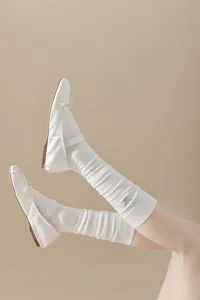 Chaussures plates blanches pour femmes avec chaussettes côtelées, style élégant.