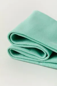 Detailed close-up view of soft light green knitted compression fabric texture and material