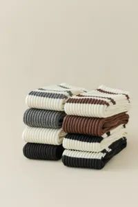 Detailed view of thick ribbed knit knee high socks in assorted stripe and solid colors.