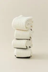 Detailed view of folded white ribbed long socks with knit texture for cozy autumn daily wear.