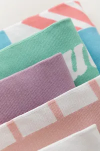 Close-up detail of colorful knitted over-the-knee socks showing soft texture and vibrant color blocks.