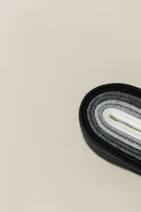 Gros plan détaillé de chaussettes en tricot côtelé roulées en dégradé de couleurs.