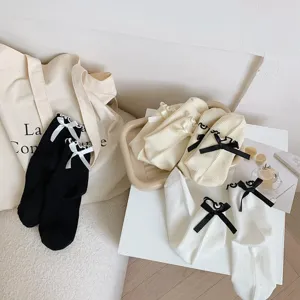 Chaussettes à volants style japonais JK avec nœuds, vue détaillée des chaussettes noires et blanches.