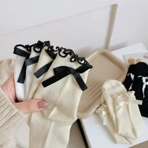 Vue détaillée de chaussettes JK Lolita japonaises mignonnes avec dentelle et nœuds noirs.