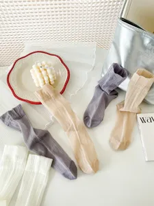 Close-up of sheer summer long socks in assorted colors displayed with lifestyle props.