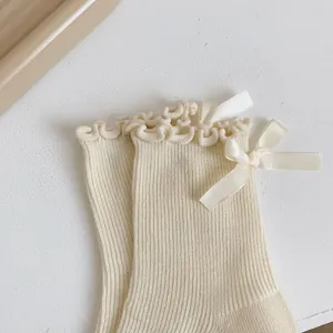 Gros plan de chaussettes à volants avec nœud, style doux, texture en tricot doux et confortable.