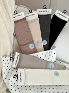 Detailed shot of mulberry silk mid-calf socks in various solid colors with tags.