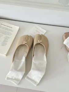 Beige split-toe flats paired with white socks, minimalist design comfortable daily wear