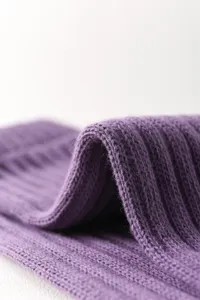 Purple ribbed knit texture detail shot of sports compression yoga socks and leg warmers.