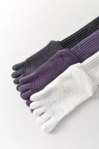 Detailed view of long five-toe yoga socks featuring anti-slip grip soles for pilates and sports.