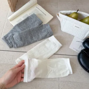 Detailansicht der einfarbigen kurzen Steigbügel Beinstulpen und weichen Baumwollsocken.