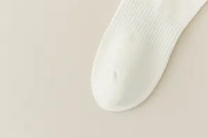 Close-up detail of a white ribbed sock toe, showing soft knit texture and fine craftsmanship.
