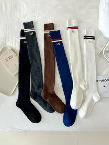 Knit over-the-knee socks detailed view showing classic stripes and embroidery accents.