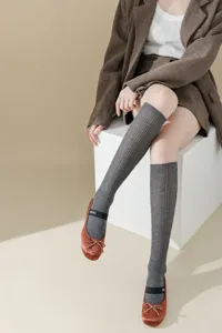 Women grey knit knee high socks paired with satin ballet flats, chic vintage autumn style.