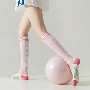 Stylish pink knee-high athletic socks for women, featuring non-slip grip soles and stripes.