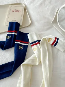 Close-up details of Japanese style over-knee knit socks featuring embroidery and stylish stripes.