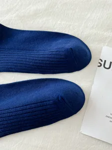 Close-up detail of dark blue ribbed JK socks, showing fine knit texture and neat toe construction.