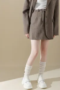 Detailed shot of women chunky knit slouch socks paired with stylish blazer and loafers outfit.