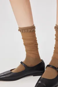 Ultra-thin mesh calf socks feature delicate ruffed cuff, showing fine knitwear texture close-up.