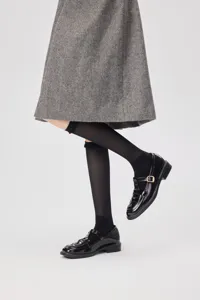 Detail view of women sheer mesh knee high socks styled with chic shoes for daily summer wear.
