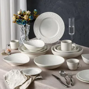 Service de vaisselle en céramique mate minimaliste, assiettes, bols et tasses blancs.