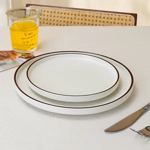 Minimalist ceramic dinner plate set with elegant brown rim, perfect for modern dining.
