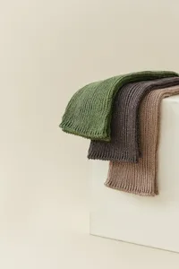 Detailed close-up of chunky knit metallic slouch socks in green, dark grey and camel colors.