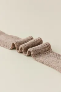 Close-up detail of shimmering metallic knit fabric showing soft texture and folded design.