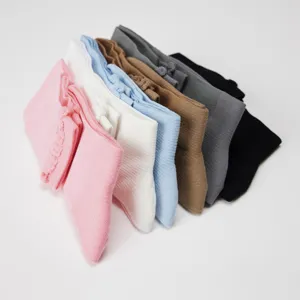 Close-up detail showing multi-color stacked knee-high mesh socks with delicate top knit bow.