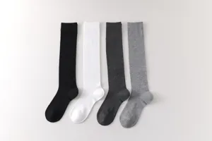 Detalle de calcetines largos lisos para pantorrilla, textura de punto suave y presentación pulcra.