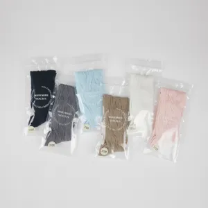 Detailed shot of multiple colors of soft ribbed ballet style long socks neatly packaged.