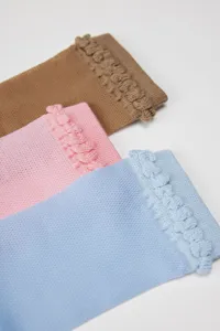 Close-up detail of ultra-thin mesh over-the-knee women socks with cute ruffled cuffs in multi-colors.