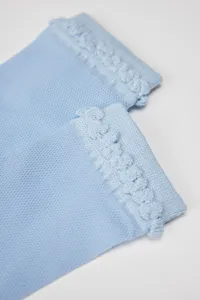 Detailed view of light blue breathable mesh knit over-the-knee socks with stylish ruffled cuffs.
