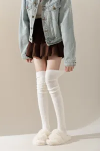 Detailopname van witte overknee gebreide sokken, comfortabel en warm voor de winter.