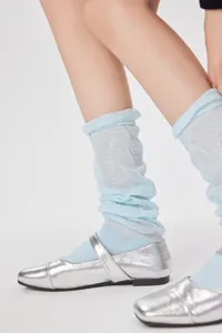 Detailed close-up of light blue thin scrunchie socks paired with stylish silver flats.