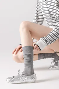 Primer plano de calcetines grises a media pantorrilla con textura suave y pliegues.