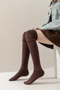 Detailopname van bruine over-de-knie geribbelde sokken, zachte warme winterbeenmode stijl.