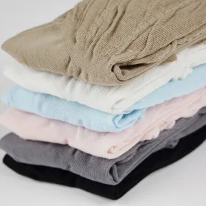 Detailed view of stacked solid color knit socks in multi colors, soft and breathable fabric.